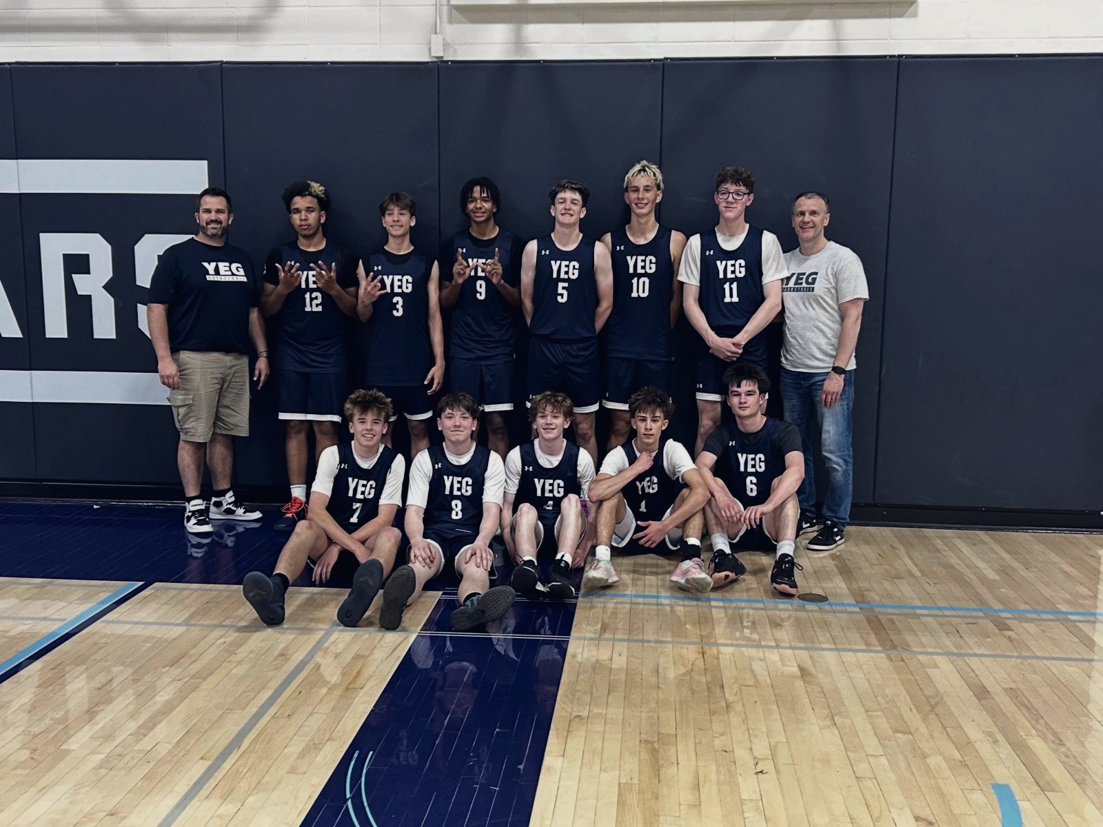 A YEG BASKETBALL boys team with their coaches in Cardston